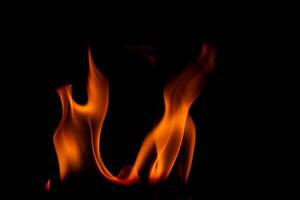 heiß Flammen auf ein schwarz Hintergrund. schön Flamme von Feuer im das dunkel. abstrakt von Verbrennung Flammen und Rauch. foto