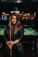 ein Mädchen mit ein Stichwort im ihr Hände ist Stehen im ein Billard- Club.Russisch Billard foto