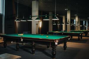 Dort sind ein Menge von Billard- Tabellen mit Grün Oberflächen und Bälle im das Billard- Verein foto