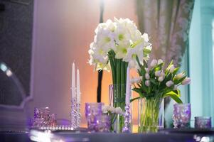 Dekoration von ein festlich Abendessen mit Lilie Blumen auf das Hochzeit Tabelle im das Innere von das Restaurant.Hochzeit Dekor. foto