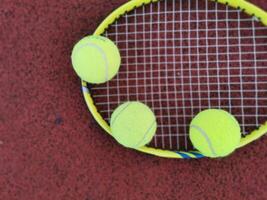 Tennis. Tennis Ball und Schläger auf ein rot Hintergrund von Tennis Gericht mit Kopieren Raum. Sport und gesund Lebensstil. das Konzept von draussen Spiel Sport. foto