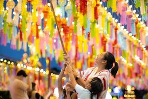 asiatisch Familien machen wünscht sich und hängen Laternen während das hundert tausend Laterne Festival oder yi peng Festival im Nord Thailand. foto