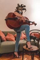 attraktiv Frau tragen ein Maske ist spielen ein Cello foto