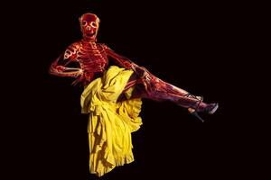 sinnlich Frau gekleidet im ein Skelett Kostüm schwebend im das Luft tragen ein Gelb Rock foto
