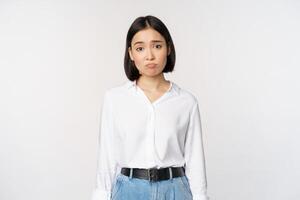 Bild von traurig Büro Mädchen, asiatisch Frau schmollen und runzelte die Stirn enttäuscht, Stehen verärgert und betrübt gegen Weiß Hintergrund foto