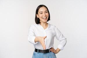 Bild von zuversichtlich asiatisch Frau lächelnd, erweitern Hand zum Handschlag Gruß Geste, Sprichwort Hallo, Stehen Über Weiß Hintergrund foto