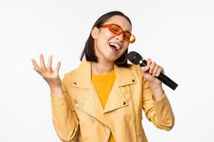 Singen Mädchen halten Mikrofon, durchführen Lieder beim Karaoke, Stehen Über Weiß Hintergrund foto