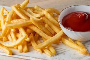 heiße goldene Pommes frites mit Sauce auf Holzhintergrund. hausgemachtes rustikales Essen. foto