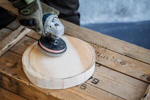 Erstellen ein Teller von natürlich Material. runden hölzern Platte. ein schließen Schuss von das Hände von ein Meister Holzschnitzer. Carving ein runden Teller von ein Platz Stück von Holz. Behandlung von hölzern Oberfläche foto