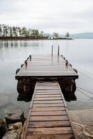 hölzern Seebrücke zum Boote auf See Turgoyak. felsig Strand. foto