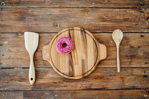 ein Teller mit ein Rosa Krapfen foto