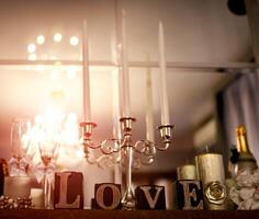 Hochzeit Dekoration. Kerzenhalter und hölzern Liebe Briefe im das Mirrow Betrachtung Hintergrund. foto