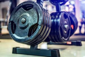 schwarz Hantel Metall Platten auf ein Hintergrund von Sport, Fitness Verein. modern Festplatten zum Hantel im das Fitnessstudio. schließen hoch. Fitnessstudio Ausrüstung Konzept. foto