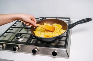 gebraten Kartoffeln beim Zuhause im ein braten schwenken foto