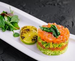 Lachs Tartar mit Avocado auf Teller foto