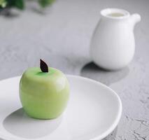 Apfel geformt Mousse Kuchen und Tee foto