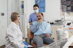 Kieferorthopäde Senior Frau Arzt erklären Oral Hygiene zu geduldig mit Zahnschmerzen diskutieren Gesundheitswesen Behandlung während stomatologisch Beratung im Dental Büro Zimmer. Konzept von Medizin Bedienung foto