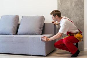 jung Arbeiter Aufzug oben schwer Sofa. jung Männer von ziehen um Unternehmen und LKW Lieferung Bedienung entfernen Dinge von das Haus, Tragen Möbel und andere Besitz foto