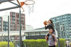 glücklich Vater und Teen Tochter draußen beim Basketball Gericht. foto