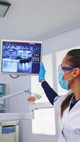 Zahnarzt Arzt und geduldig suchen beim Digital Teeh Röntgen im Dental Büro, Person pov. Stomatologie tragen schützend Gesicht Maske und Handschuhe zeigen beim Zähne Radiographie im stomatologisch Klinik foto
