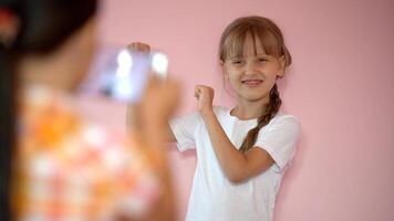 zwei wenig Mädchen nehmen Foto mit ein Smartphone