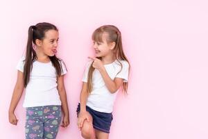 zwei Mädchen Kampf Über ein Rosa Hintergrund foto