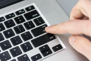 Finger schieben das Taste von Tastatur foto