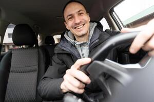 meine Baby. Schuss von ein glücklich Mann Sitzung im seine Auto berühren das Instrumententafel sanft lächelnd fröhlich foto