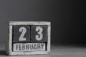 Februar 23 auf hölzern Kalender, auf dunkel grau Hintergrund. foto