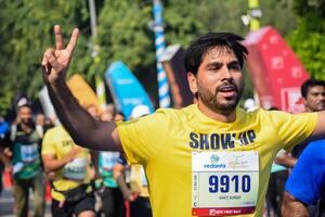 Neu Delhi, Indien - - Oktober 15 2023 - - Vedanta Delhi Hälfte Marathon- Rennen nach covid im welche Marathon- Teilnehmer Über zu Kreuz das Fertig Linie, Delhi Hälfte Marathon- 2023 foto