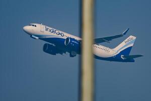 Neu Delhi, Indien, Dezember 25 2023 - - Indigo Airbus a320 nehmen aus von indra Gandhi International Flughafen Delhi, Indigo inländisch Flugzeug fliegend im das Blau Himmel während Tag Zeit foto