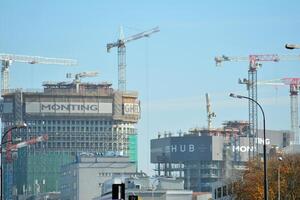 hoch erhebt euch Gebäude unter Konstruktion. Installation von Glas Fassade Paneele auf ein verstärkt Beton Struktur. foto