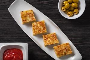 spanische Tapa, Omelette, Oliven und Sauce foto