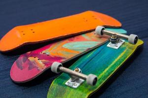 Miniatur-Holz-Skateboard-Griffbrettspielzeug auf blauem Holzhintergrund foto