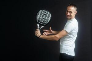 Padel Tennis Spieler mit Schläger im Hand. Paddel Tennis, auf ein schwarz Hintergrund. foto