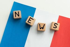 Konzept Nachrichten Einspeisungen - - brechen Nachricht, Französisch Landes Flagge, Tafel und das Text neueste Nachrichten auf hölzern Hintergrund foto