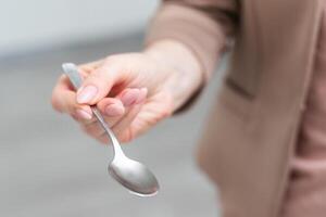 metallisch leeren Essen Löffel im ein Mensch richtig Hand mit Ausschnitt Pfad isoliert auf Weiß foto