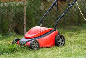 Rasen Mover beim Arbeit auf ein Grün Wiese beim Sommer foto