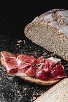 Brotscheibe gewürzt mit Serrano-Schinken foto