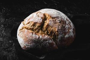 dunkles hausgemachtes Brot mit Mehl bestäubt foto