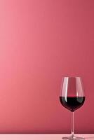 ai generiert ein Single Glas von rot Wein auf ein Rosa Hintergrund. foto