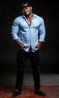 modern muskulös Bodybuilder im Blau Hemd posieren zum Kamera. Fitness gut aussehend Mann Stehen im Studio auf schwarz Hintergrund. foto