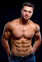 Porträt von stark gesund gut aussehend sportlich Mann Fitness Modell- isoliert auf dunkel Hintergrund. suchen zu das Kamera. Nahaufnahme. foto