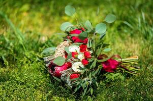 Hochzeit Strauß auf ein Gras. Grün Hintergrund. hell Rosen und lila Schleife. draussen. Nahaufnahme. foto