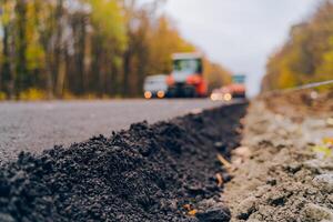 Verlegung ein Neu Asphalt auf das Straße. Arbeiter Betriebs Asphalt Fertiger Maschine während Straße Konstruktion. Konstruktion von das Straße. foto