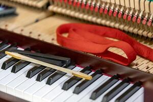 flach Fokus Nahansicht von Werkzeuge zum Tuning das intern Mechanismen von ein aufrecht Klavier. gibt ein Gefühl von Luxus, klassisch, Luxus, Größe. Bilder können Sein benutzt auf verschiedene Themen verbunden zu Musik. foto