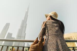 schöne junge kaukasische touristin genießt einen panoramablick von den marina-pools in der innenstadt von dubai. reisebesuch dubai konzept. Banneraufnahme aus niedrigem Winkel foto