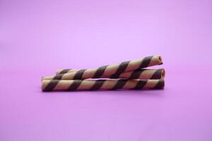Wafer Stock isoliert lila Hintergrund. 2 Schokolade mit ...-Geschmack Wafer Stöcke. foto