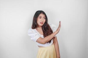 jung asiatisch Frau isoliert auf Weiß Hintergrund, sieht aus besorgt, gestikulieren Ablehnen durch ihr Hand, erschrocken und nervös. foto