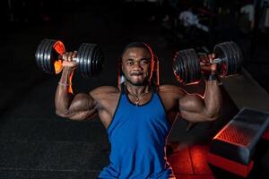 gut aussehend Mann mit groß Muskeln Pumpen im das Fitnessstudio. jung Bodybuilder Ausbildung Bizeps. foto